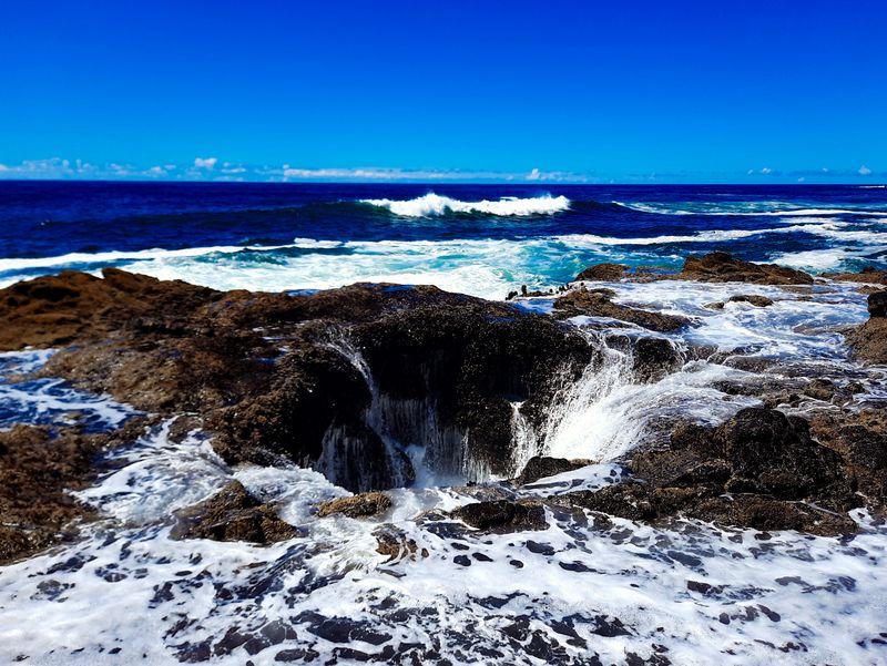 Ocean waves draining into Thor's Well, a churning sinkhole in the rocky Oregon coastline